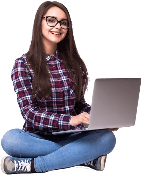 a woman wearing glasses sits on the floor with a laptop in front of her
